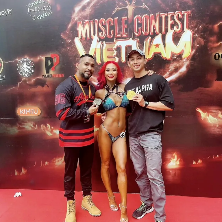 EJ Philip Joshua with an Alpha Beast athlete holding her medal at Muscle Contest Vietnam